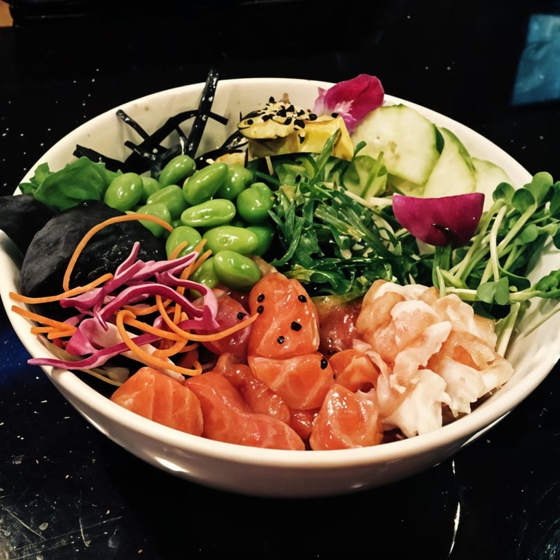 A colorful poke bowl with salmon, shrimp, edamame, avocado, cucumber, and various greens.